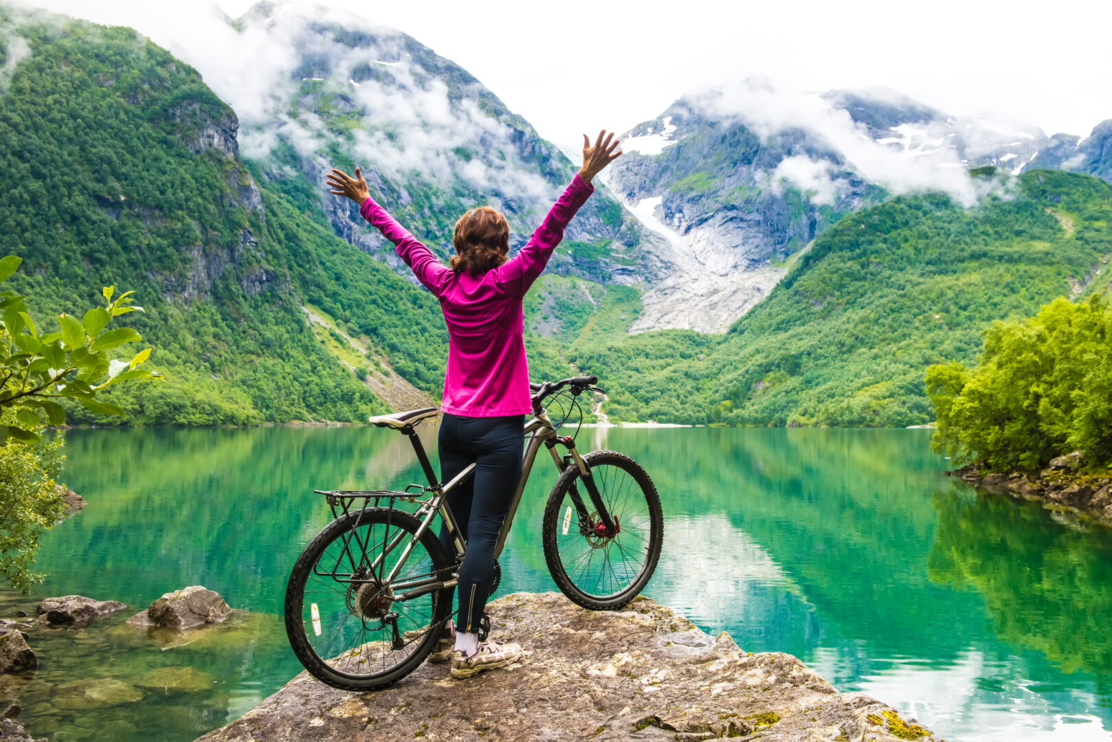 Femme cycliste en Norvège face à un lac