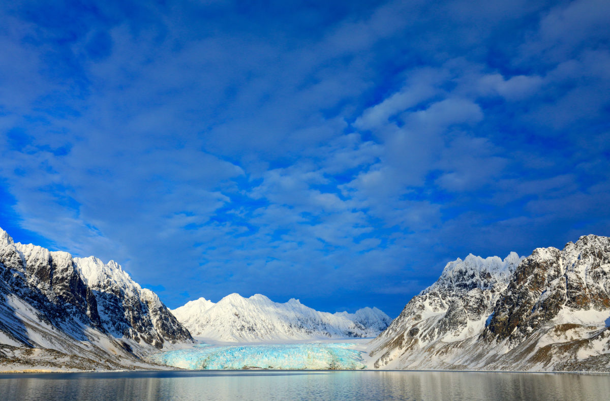 Montagnes enneigées et glacier bleu au Svalbard, Norvège