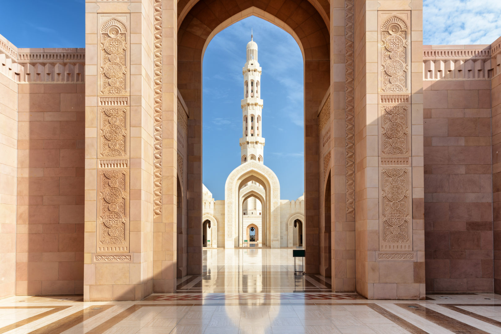 Vue minaret à travers les arches de la Grande mosquée Sultan Qaboos à Mascate, Oman