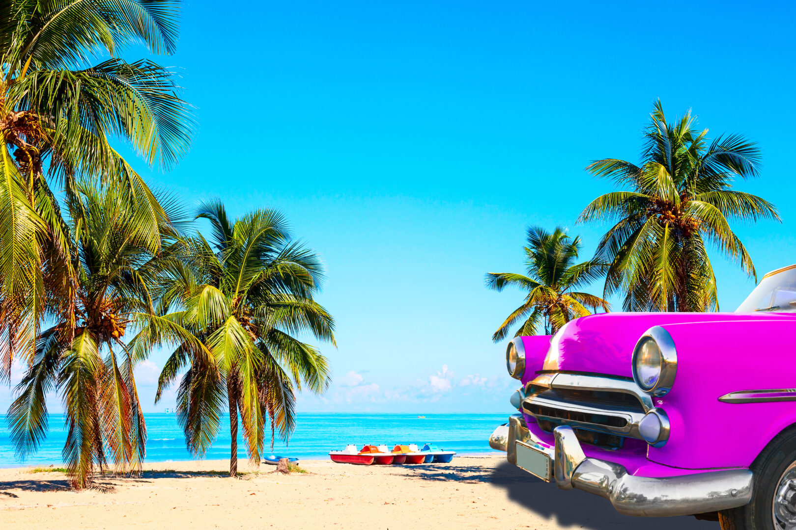 Plage de Cuba avec palmiers et une voiture ancienne rose